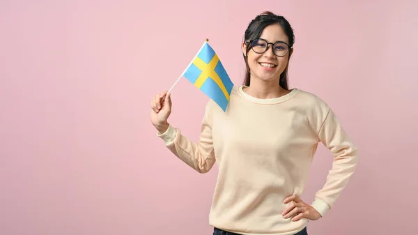 Mladá Asijská Dívka Ukazuje Švédskou Vlajku Růžové Izolované Pozadí Vzdělávací — Stock fotografie