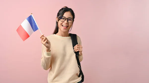 Vrolijk Aziatisch Meisje Toont Een Franse Vlag Roze Geïsoleerde Achtergrond — Stockfoto