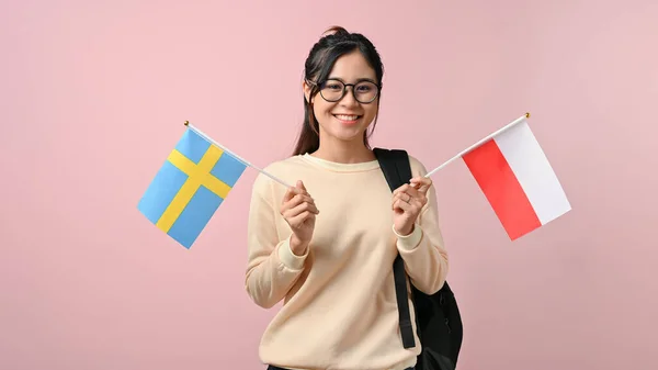 Šťastná Mladá Asiatka Ukazující Polsko Švédsko Vlajku Růžovém Izolovaném Pozadí — Stock fotografie