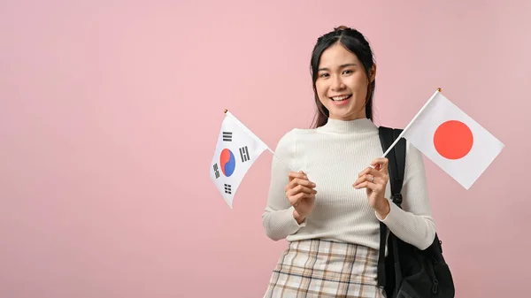 Šťastná Mladá Asiatka Ukazující Japonskou Jihokorejskou Vlajku Růžovém Izolovaném Pozadí — Stock fotografie