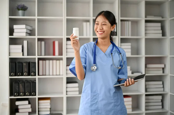 Νεαρή Γυναίκα Επαγγελματίας Γιατρός Κρατώντας Ένα Μπουκάλι Χάπια Ενώ Στέκεται — Φωτογραφία Αρχείου