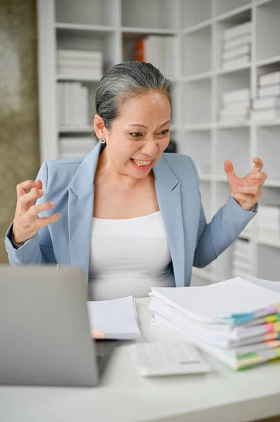 Stock image Overworked stressful senior businesswoman feeling upset about the workload and deadlines. 