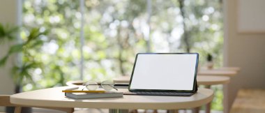 Çalışma alanı tablet beyaz ekran maketi, kablosuz klavye, gözlük ve kitapla en az çalışma alanı olan bir ahşap masa üzerinde. 3d görüntüleme, 3d illüstrasyon