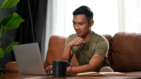 Gerichte Slimme Duizendjarige Aziatische Man Zoek Naar Zijn Laptop Scherm — Stockfoto