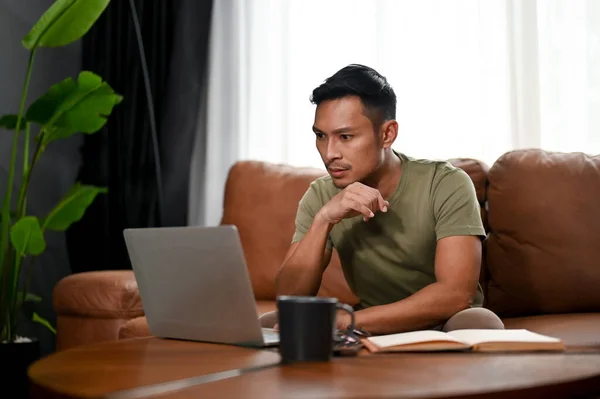 Gericht Duizendjarige Aziatische Man Zoek Naar Zijn Laptop Scherm Denken — Stockfoto