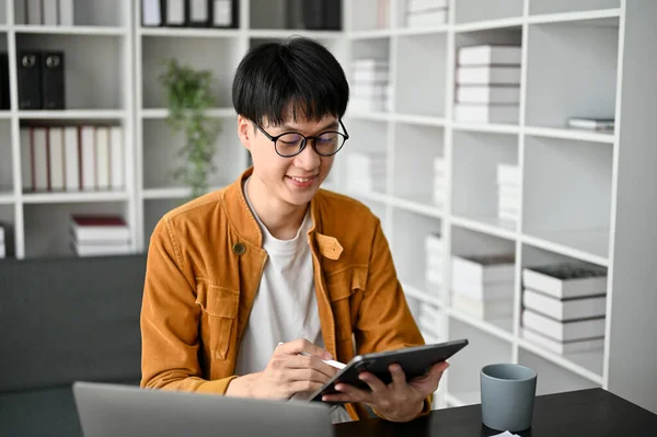 stock image Close up view of young Asian college student study in the study room with laptop digital tablet and textbooks. 