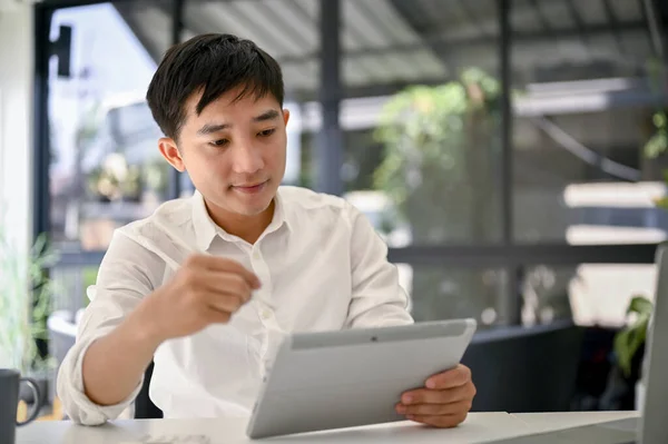 생각깊은 밀레니엄 아시아 사업가 보스는 태블릿을 사용하여 사무실에서 일하는 프로젝트를 — 스톡 사진
