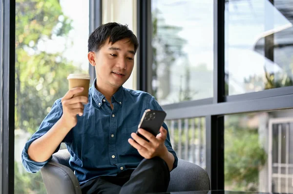 Feliz Hombre Asiático Milenario Usando Teléfono Inteligente Disfrutando Café Una — Foto de Stock