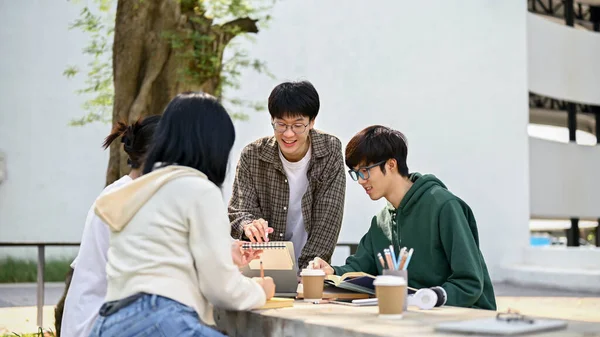 잘생긴 아시아 대학생 주말에 캠퍼스 공원에서 친구들에게 수학을 가르치고 있습니다 — 스톡 사진