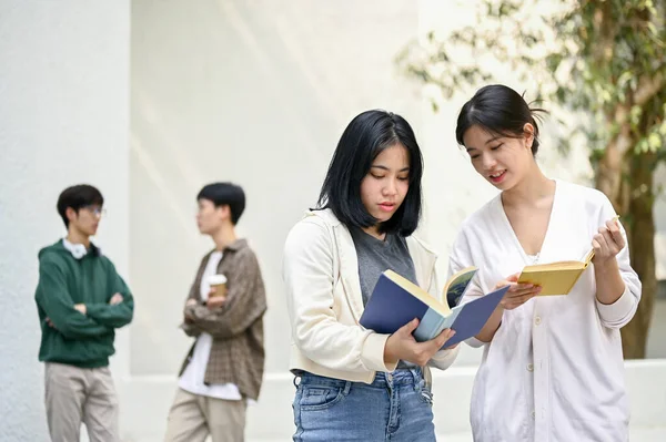 Двоє Чарівних Студентів Азіатського Коледжу Обговорюють Шукають Інформацію Книжці Стоячи — стокове фото