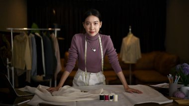 Bin yıllık başarılı Asyalı kadın moda tasarımcısının ya da stüdyosundaki masasında duran terzinin portresi..