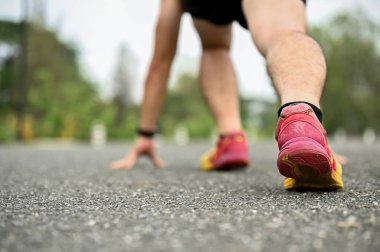 Spor giyimli bir adamın arka görüntüsü başlangıç pozisyonunda, koşmaya hazırlanıyor. seçici odak koşu ayakkabıları