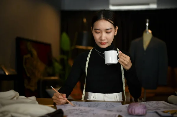 Концентрированная Профессиональная Азиатская Модельер Тысячелетия Потягивает Кофе Работает Над Своей — стоковое фото