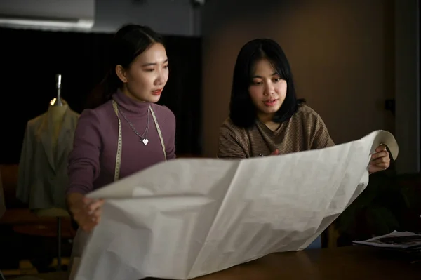 Две Азиатские Женщины Портнихи Модельеры Обсуждают Проверяют Качество Ткани Своей — стоковое фото