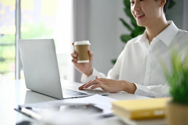 아시아 사업가가 커피를 마시고 노트북 컴퓨터를 사용하여 커피숍에서 온라인으로 업무를 — 스톡 사진
