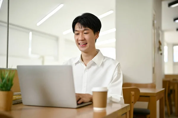 셔츠를 커피숍에서 일하는 아시아 자신의 업무를 수행하기 노트북 컴퓨터를 사용하는 — 스톡 사진