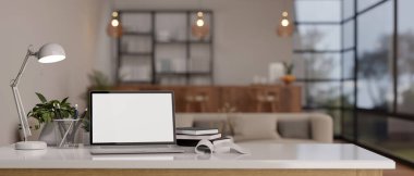 Çalışma alanı laptop boş ekran modeli, kitaplar, kırtasiye malzemeleri, masa lambası ve modern oturma odasında dekor bitkisi. 3d görüntüleme, 3d illüstrasyon