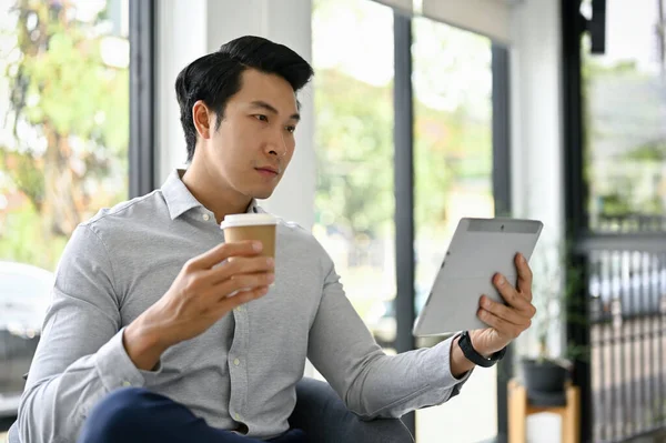 천년기 사업가가 커피를 마시고 사무실 라운지에서 태블릿을 사용하는 — 스톡 사진