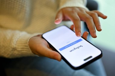 Chiang Mai, Tayland - 15 Mayıs 2023: Bir kafede dinlenirken Instagram hesabındaki bir kadının yakın plan resmi. iPhone ekranında Instagram logosu. Sosyal medya ve yaşam tarzı kavramı