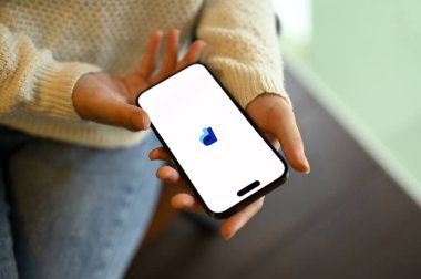 Chiang Mai, Tayland - 15 Mayıs 2023: Ekranda PayPal logosu ile akıllı telefonunu tutan bir kadının üst görüntüsü. PayPal logolu iPhone