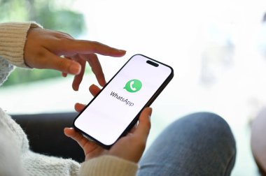 Chiang Mai, Tayland - 15 Mayıs 2023: Telefonunda WhatsApp kullanan bir kadının yakın plan görüntüsü. iPhone ekranında WhatsApp logosu.