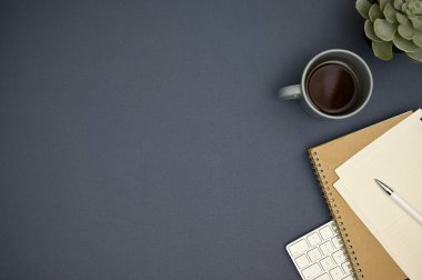 Metin veya ürün sunumunuz, kahve fincanınız, saksı bitkiniz ve kırtasiyeniz için fotokopi alanı olan modern çalışma alanı. Üst görünüm, düz uzanma