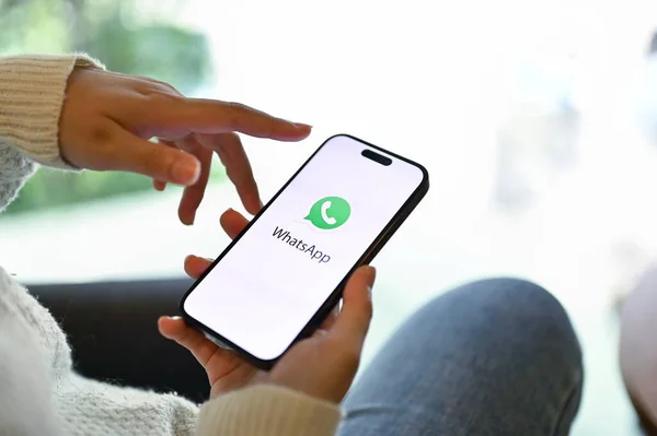 Chiang Mai, Tayland - 15 Mayıs 2023: Telefonunda WhatsApp kullanan bir kadının yakın plan görüntüsü. iPhone ekranında WhatsApp logosu.