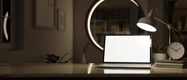 Close-up image of home workspace at night with laptop computer white screen mockup, table lamp, alarm clock and decor over blurred background of a dark room. 3d render, 3d illustration