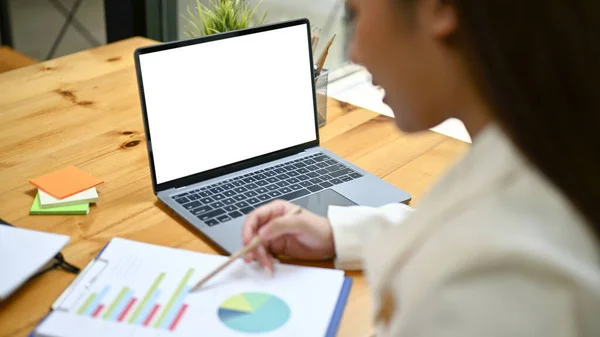美しいアジアのビジネスマンの女性が財務報告書をチェックし 彼女の机で彼女のビジネスの仕事に取り組んでいるのクローズアップイメージ ノートパソコンの白い画面のモックアップ — ストック写真