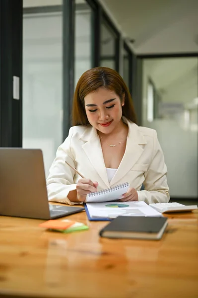 肖像画 焦点を当て オフィスで彼女の机でビジネスレポートを読み 検討白いスーツのプロの千年紀のアジアのビジネス女性 — ストック写真