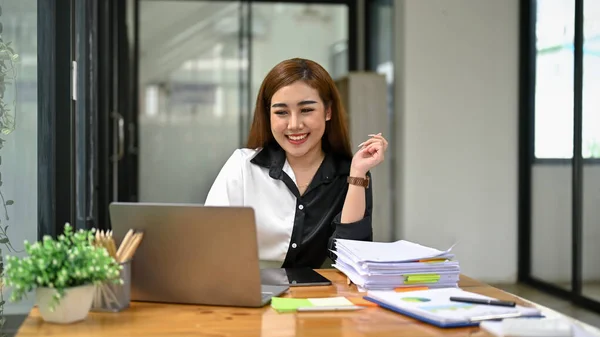 微笑而迷人的千年亚洲女商人或女会计师在她办公室的办公桌前工作 — 图库照片