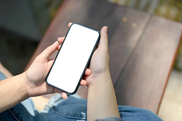 在公园的长椅上 一个年轻女孩在使用智能手机的特写镜头 智能手机白屏模型用于显示您的图形广告 — 图库照片