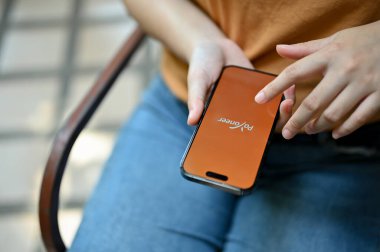 Chiang Mai, Tayland - 26 Mayıs 2023: iPhone 'unda Payonez uygulaması kullanan bir kadının yakın plan resmi.