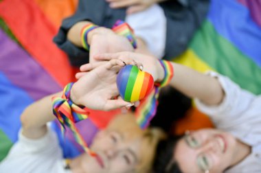LGBT 'nin çeşitli arkadaşlarının gurur bayrağının üzerinde yatıp LGBT' nin kalp sembolünü bir arada tutmalarının en üst görüntüsü. Çeşitlilik, Özgürlük, Eşitlik, LGBTQ
