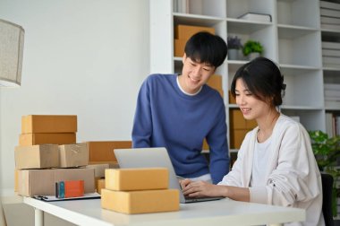 Sevimli ve mutlu bir çift evlerinde çalışıyor, ürün stoklarını planlıyorlar ve web sitesindeki müşteri geri bildirimlerini birlikte kontrol ediyorlar. Çevrimiçi satıcı, Girişim işi, E-ticaret