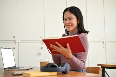Kendinden emin ve zeki bir Asyalı kız üniversite öğrencisi kahve dükkanında çalışırken bir kitaptan bilgi topladı..