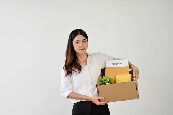 Attractive young Asian businesswoman or female office worker carrying a cardboard box with her stuff and her resignation letter. leaving job, job offer, change the company