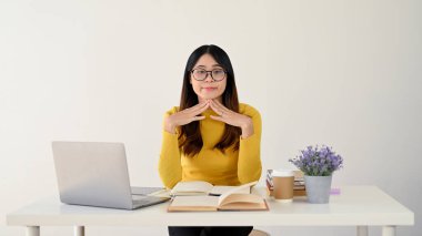 Şüpheli ve kafası karışmış genç bir Asyalı üniversite öğrencisi okul projesini ya da masasındaki ödevini düşünüyor. beyaz arkaplanda izole edilmiş