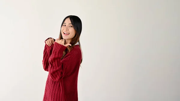 Usmívající Veselá Mladá Asijská Žena Červeném Svetru Ukazuje Palci Dozadu — Stock fotografie