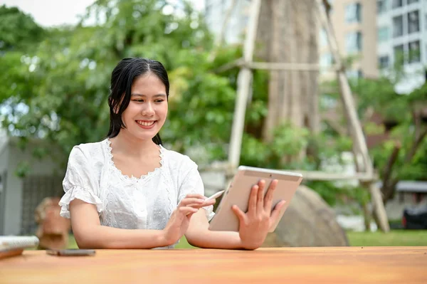 Uma Mulher Asiática Atraente Usando Seu Tablet Digital Enquanto Senta — Fotografia de Stock