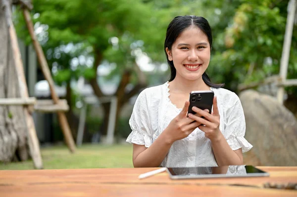 Una Mujer Asiática Sonriente Hermosa Está Mirando Cámara Sosteniendo Teléfono — Foto de Stock