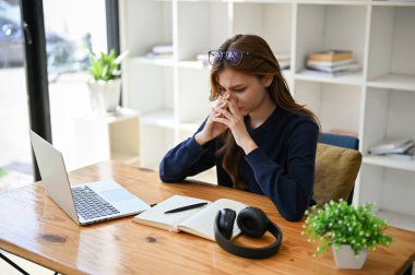 Stresli, endişeli ve düşünceli Asyalı genç bir iş kadını aşırı çalışmaktan muzdarip, işinden bıkmış ve sorunların çözümlerini bulmaya çalışıyor..