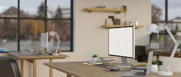 stock image A computer white screen mockup with office supplies on a table in a modern minimal co-working office. rear view. 3d render, 3d illustration