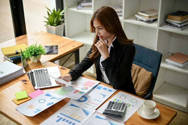 専門的で美しいアジアの実業家や女性の金融労働者は 財務報告書に取り組み オフィスの彼女の机で財務データを分析しています — ストック写真