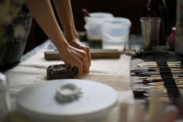 スタジオでの作業台の上で 土を編んだ男性アーティストや陶芸家の身近なリアビューのイメージ — ストック写真