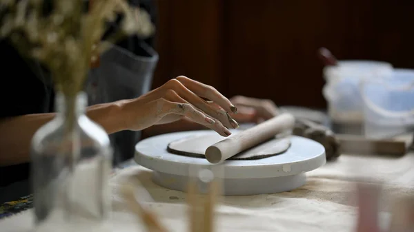 工房の机の上にある陶器の車輪の上に粘土のローラーで粘土をこねている男性アーティストのクローズアップ画像 工芸品土器彫刻家 — ストック写真