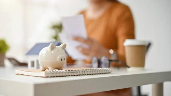 stock image Close-up image of a piggy bank is on table with a female real estate agent working behind. real estate, property investment, realtor, broker, saving, financial, banking, loan