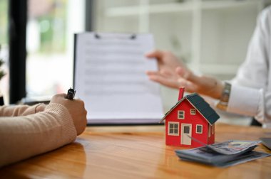 Profesyonel bir emlakçının ya da ev sigortası komisyoncusunun ofis müşterisiyle olan yakın plan görüntüsü..