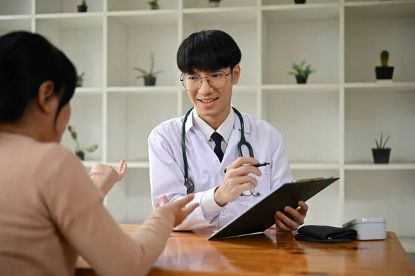 一位专业而聪明的年轻亚洲男医生在医院检查室检查一位女病人 保健概念 — 图库照片