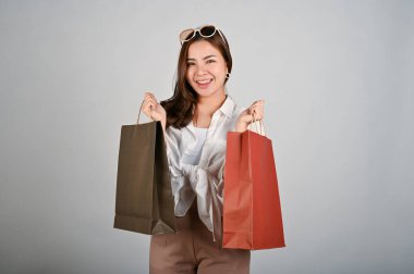 Alışveriş torbaları tutan çekici Asyalı kadın, alışveriş konsepti. beyaz izole arkaplan. 